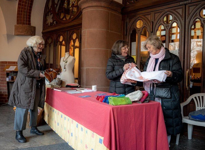 Mitglieder des Second-Hand-Teams bei der Begutachtung von Kleiderpenden