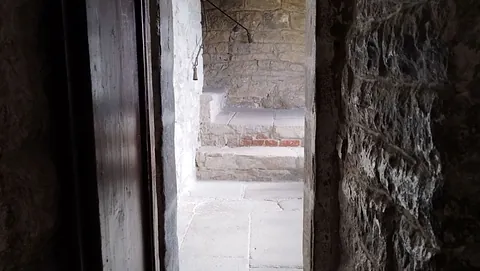 Blick durch eine geöffnete Tür zu einer Treppe, die nach oben führt. 