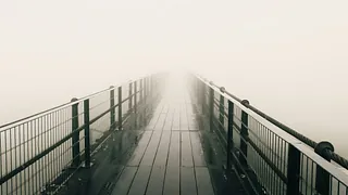 Ein Brücke führt in den Nebel